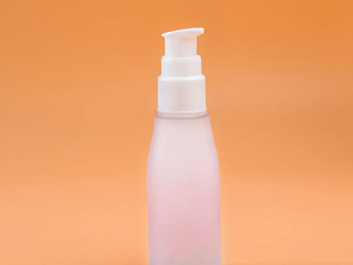 Illustrative photo of an unbranded matte pump bottle on an orange background, not an actual photo of Fenty Beauty's Pro Filt'r Soft Matte Foundation
