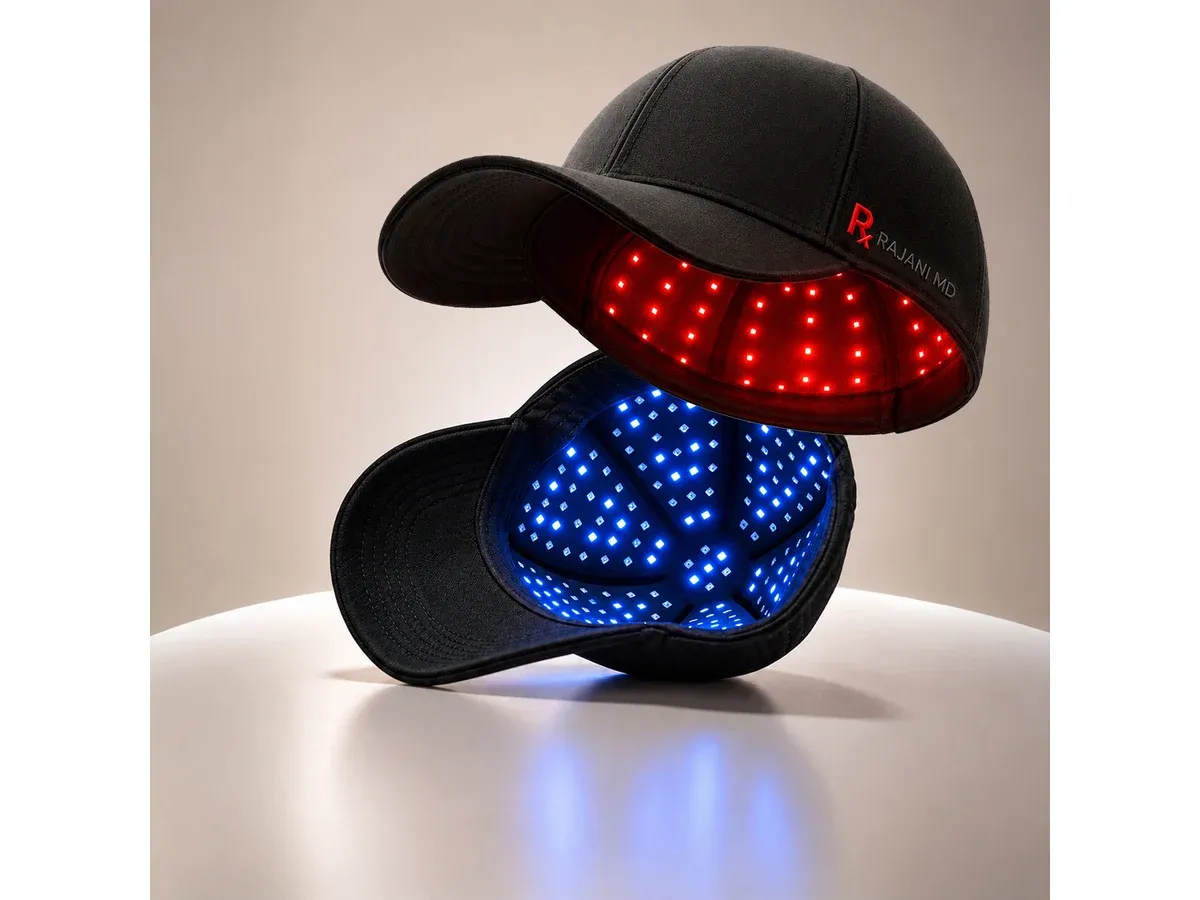 Two views of the black Rajani MD PlasmaGLO Hair+ Cap, model ZLD-500C, showing its illuminated red-light interior above and blue-light interior below; one device shown in two modes.